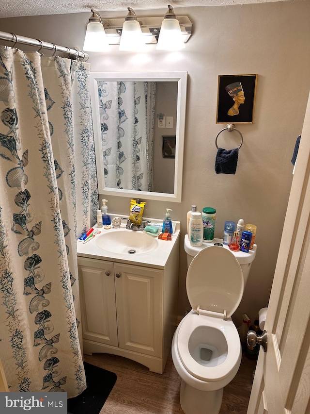 bathroom with wood-type flooring, toilet, curtained shower, and vanity