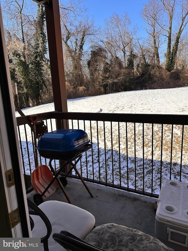 snow covered back of property with grilling area