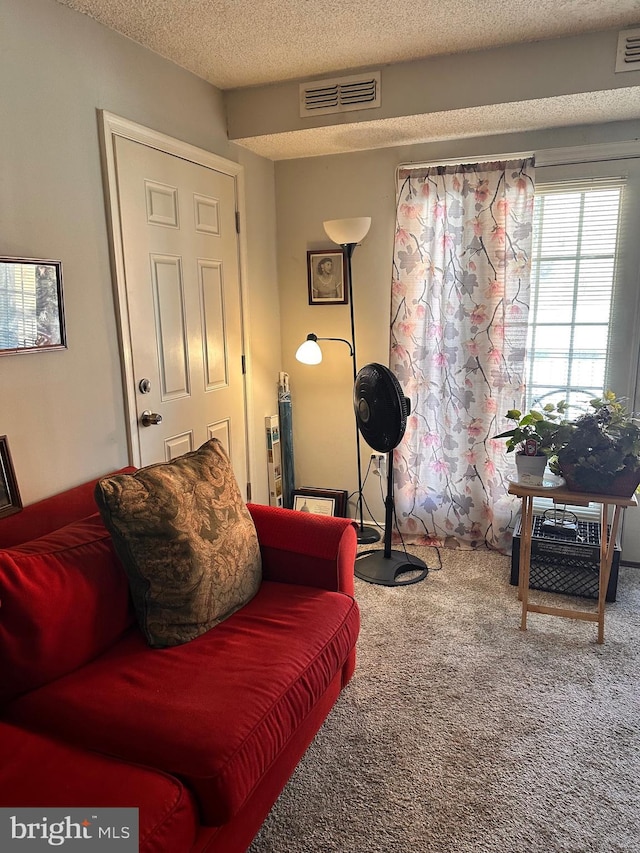 living area with a textured ceiling and carpet flooring