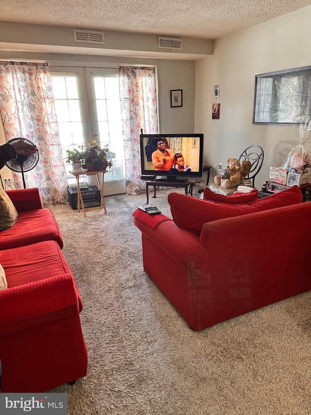 living room featuring carpet floors, a textured ceiling, and french doors