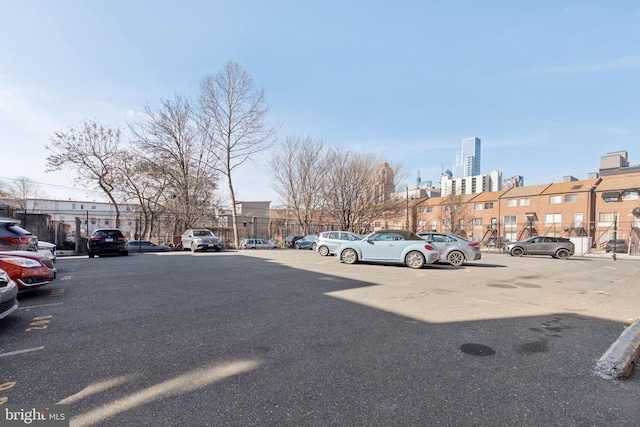 uncovered parking lot featuring a view of city