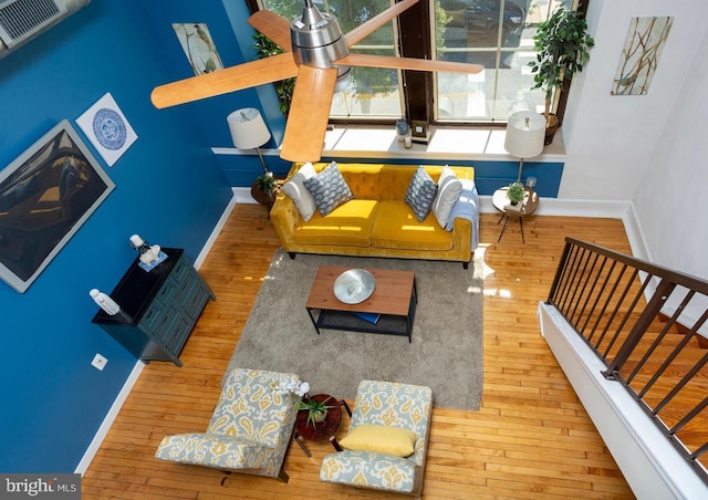 living area featuring hardwood / wood-style flooring, baseboards, visible vents, and stairway