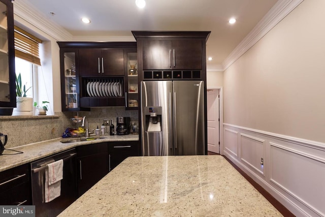 kitchen featuring appliances with stainless steel finishes, sink, and light stone counters