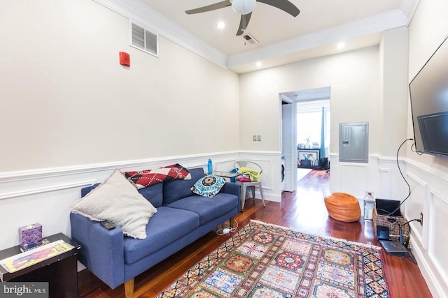 living room featuring dark wood-type flooring, ornamental molding, and ceiling fan