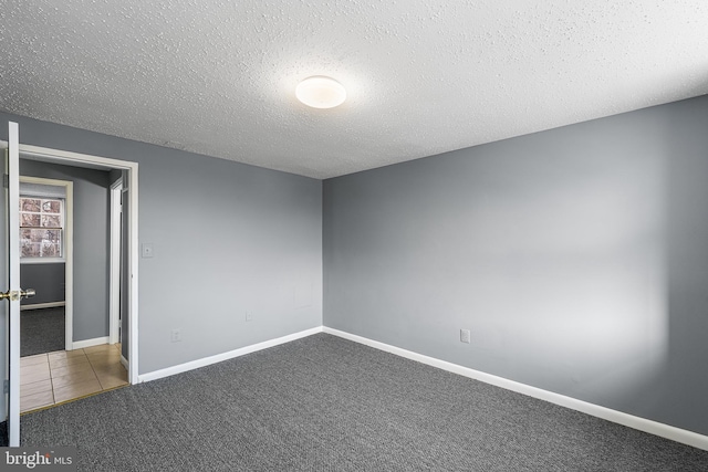 carpeted spare room featuring a textured ceiling