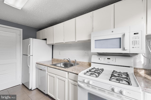 kitchen featuring sink, light tile patterned floors, white appliances, decorative backsplash, and white cabinets