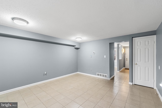 spare room with light tile patterned floors and a textured ceiling