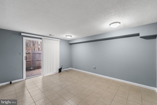 basement featuring a textured ceiling and light tile patterned floors