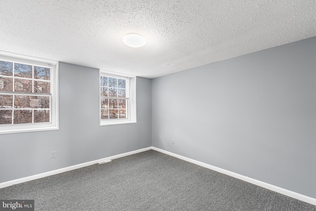 carpeted spare room with a textured ceiling