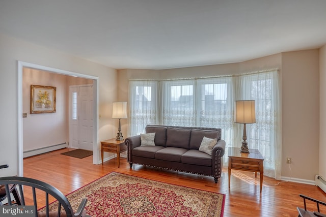 living room with baseboard heating and light wood-type flooring