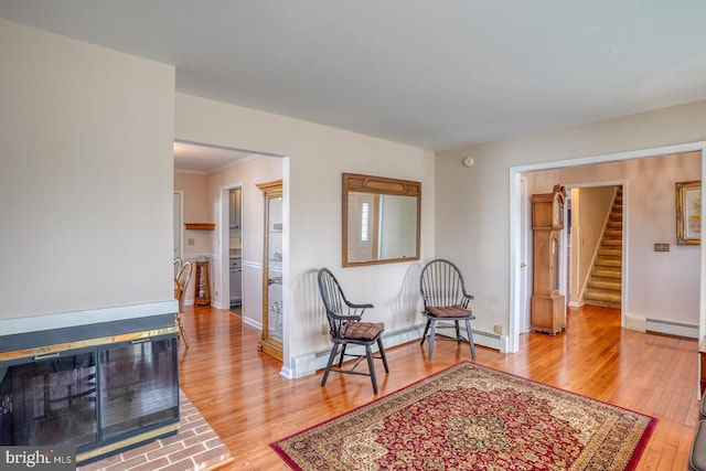 sitting room featuring crown molding, hardwood / wood-style flooring, and a baseboard radiator