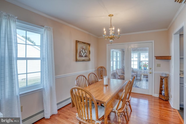 dining area with baseboard heating, crown molding, a wealth of natural light, and light wood-type flooring