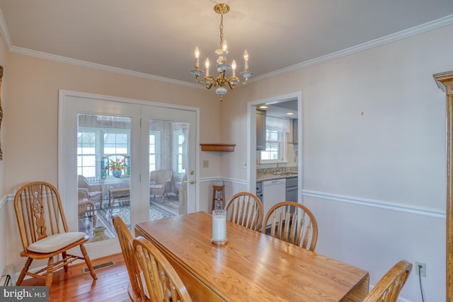 dining room featuring ornamental molding, a chandelier, and light wood-type flooring