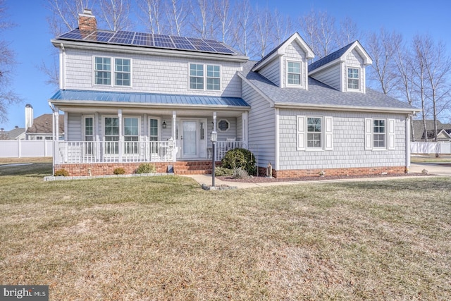 view of front facade with a front lawn, solar panels, and covered porch