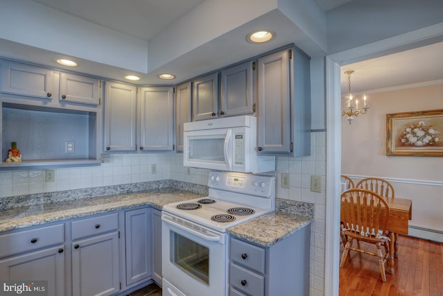 kitchen with crown molding, an inviting chandelier, wood-type flooring, white appliances, and backsplash