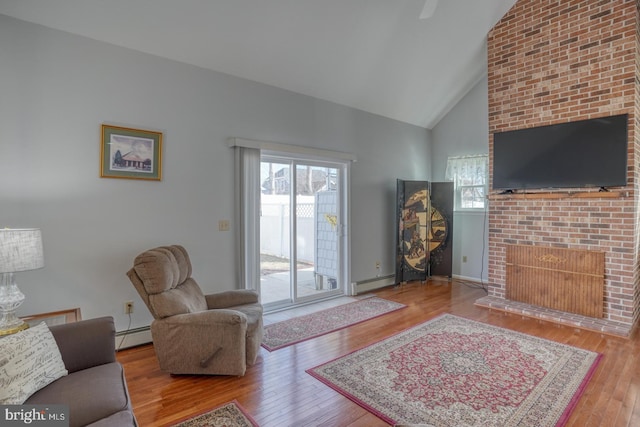 living room featuring baseboard heating, high vaulted ceiling, a fireplace, and hardwood / wood-style floors