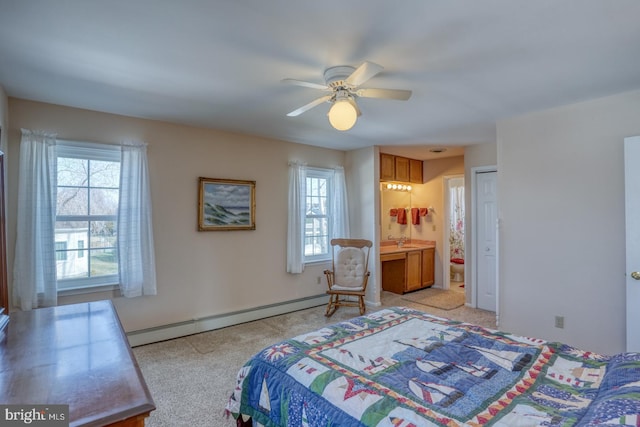 carpeted bedroom with multiple windows, ensuite bath, a baseboard radiator, and ceiling fan