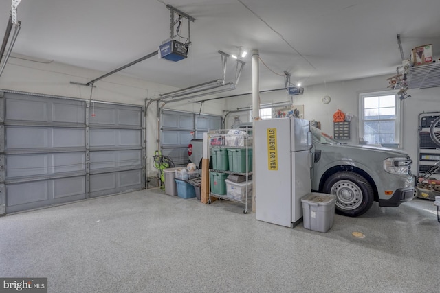 garage featuring a garage door opener and white fridge