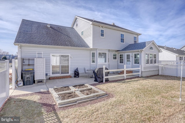 back of property with a yard and a patio