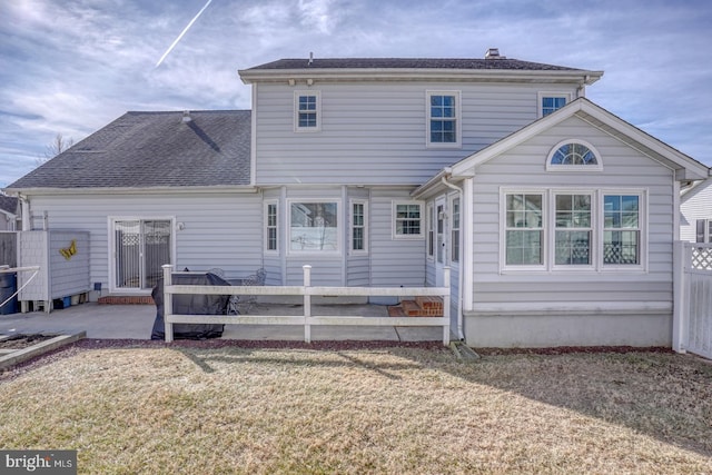 rear view of house with a lawn and a patio