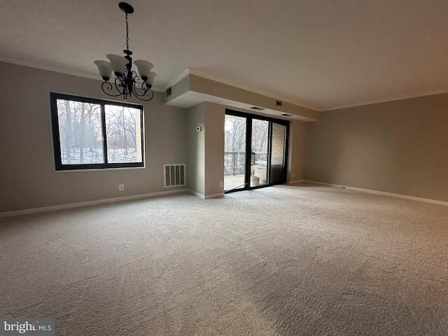 carpeted spare room with crown molding and a chandelier