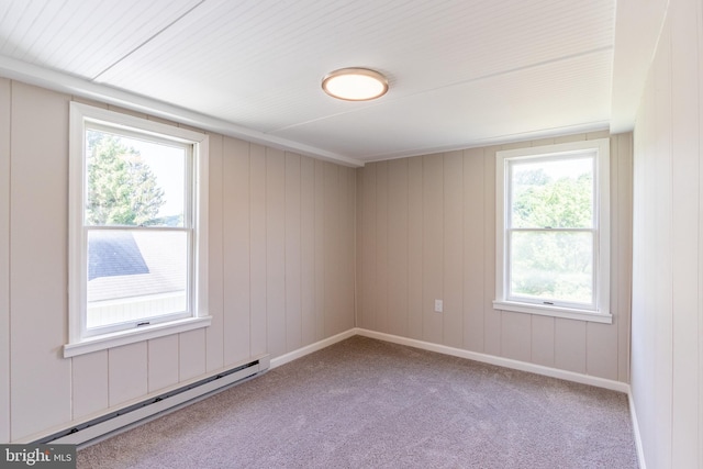 carpeted empty room featuring a wealth of natural light and baseboard heating