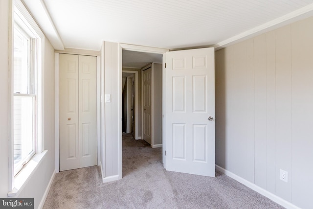 unfurnished bedroom featuring light colored carpet and a closet