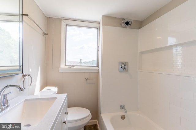 full bathroom featuring tiled shower / bath combo, vanity, and toilet