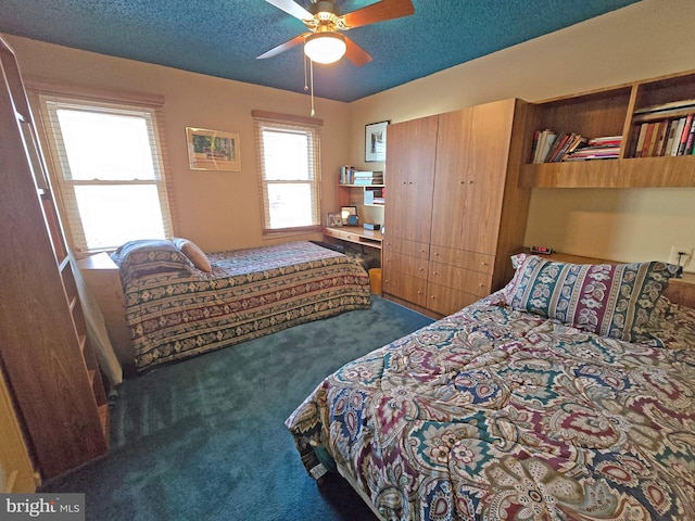 carpeted bedroom featuring ceiling fan and a textured ceiling