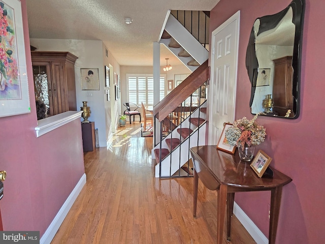 corridor featuring light hardwood / wood-style floors and a textured ceiling