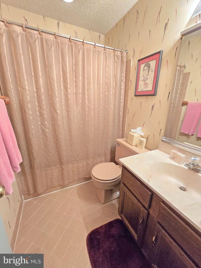 bathroom featuring tile patterned flooring, vanity, a textured ceiling, and toilet