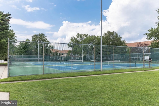 view of tennis court featuring a yard