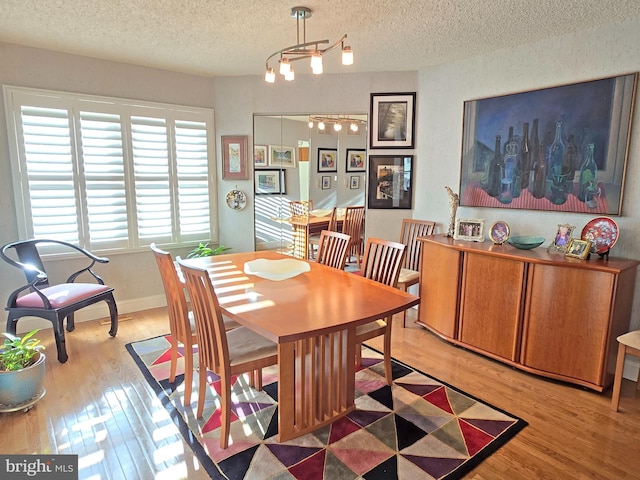 dining room with hardwood / wood-style flooring and a textured ceiling