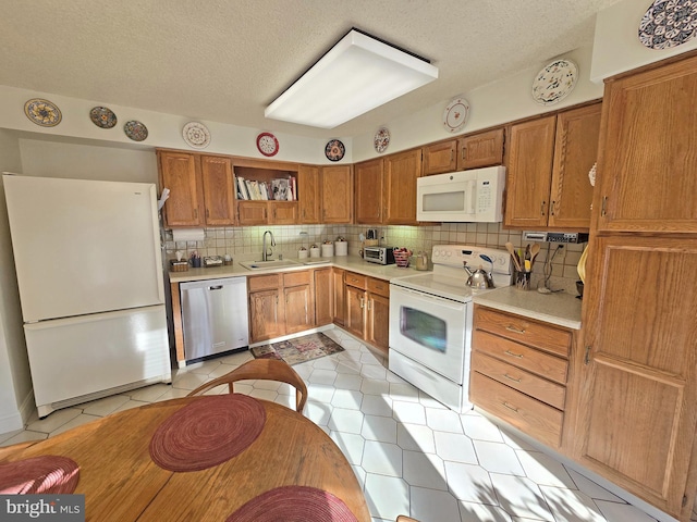 kitchen featuring light tile patterned flooring, sink, backsplash, and white appliances