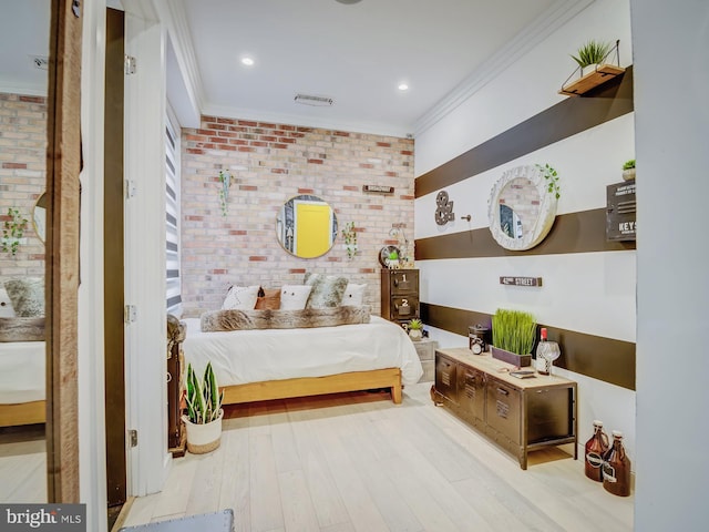 bedroom featuring crown molding, brick wall, and light hardwood / wood-style flooring