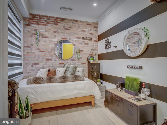 bedroom with light hardwood / wood-style flooring, ornamental molding, and brick wall