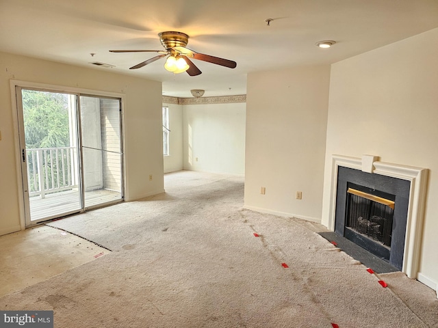 unfurnished living room featuring plenty of natural light, light colored carpet, and ceiling fan