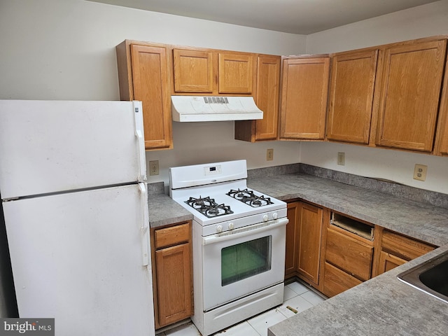 kitchen with white appliances, sink, and light tile patterned floors