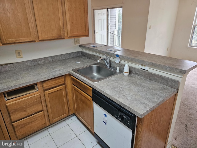 kitchen with white dishwasher, kitchen peninsula, sink, and light tile patterned floors