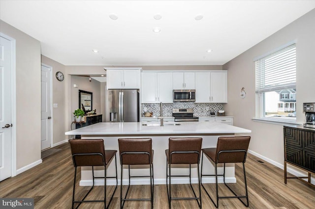 kitchen with sink, a center island with sink, white cabinets, and appliances with stainless steel finishes