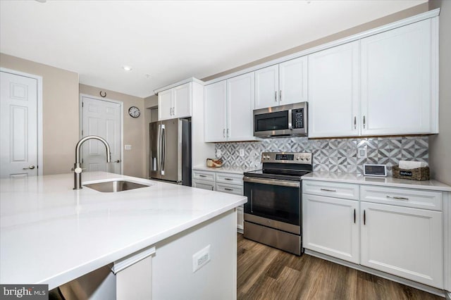 kitchen featuring appliances with stainless steel finishes, dark hardwood / wood-style floors, tasteful backsplash, sink, and white cabinets