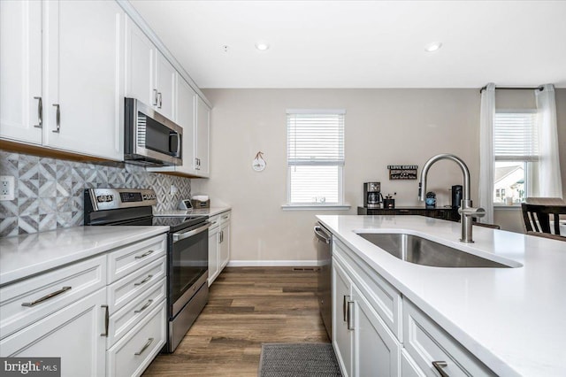 kitchen featuring sink, appliances with stainless steel finishes, tasteful backsplash, a healthy amount of sunlight, and white cabinets