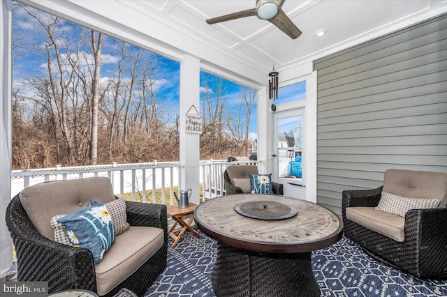 sunroom / solarium with coffered ceiling, ceiling fan, and a healthy amount of sunlight