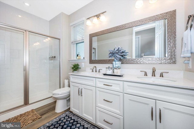 bathroom featuring an enclosed shower, vanity, hardwood / wood-style floors, and toilet