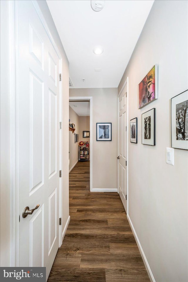 corridor with dark hardwood / wood-style flooring