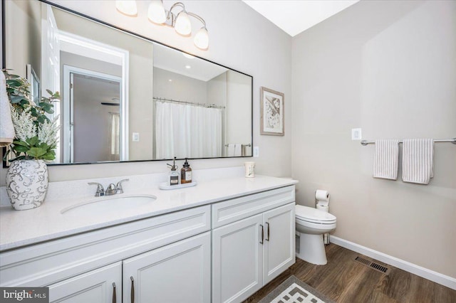 bathroom featuring vanity, hardwood / wood-style flooring, a shower with curtain, and toilet