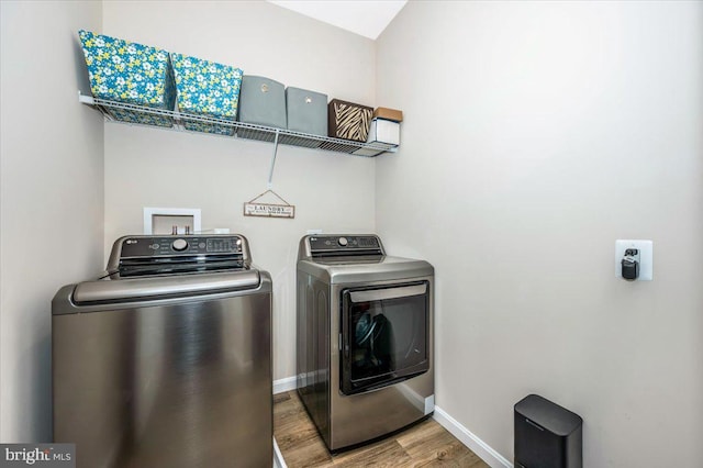 laundry room with wood-type flooring and washer and dryer