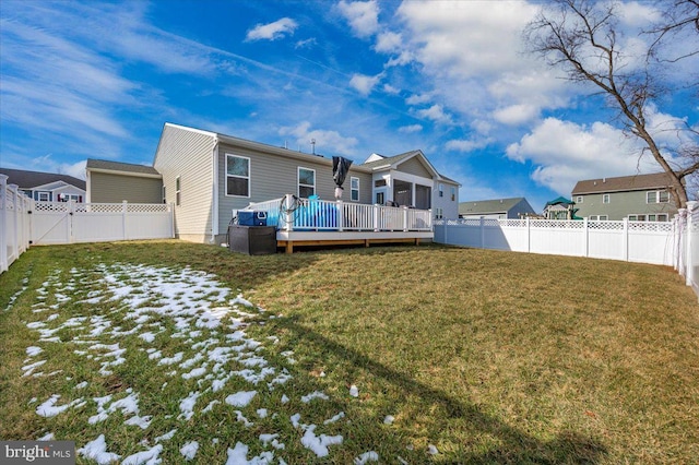 rear view of property featuring a yard and a deck