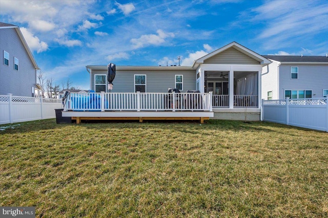 rear view of house with a yard, a sunroom, and a deck