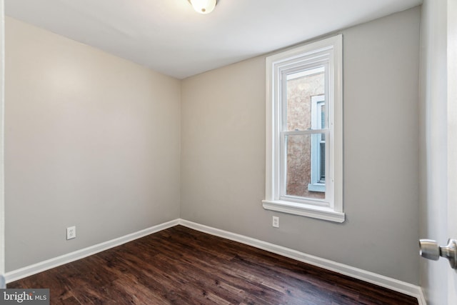 unfurnished room with dark hardwood / wood-style flooring